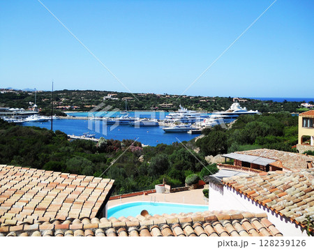 Stunning panoramic view of Porto Cervo, a luxurious seaside resort on the Costa Smeralda in northern Sardinia, Italy. The image features a picturesque harbor filled with elegant white yachts and Stunning panoramic view of Porto Cervo, a luxurious seaside resort on the Costa Smeralda in northern Sardinia, Italy. The image features a picturesque harbor filled with elegant white yachts and 128239126