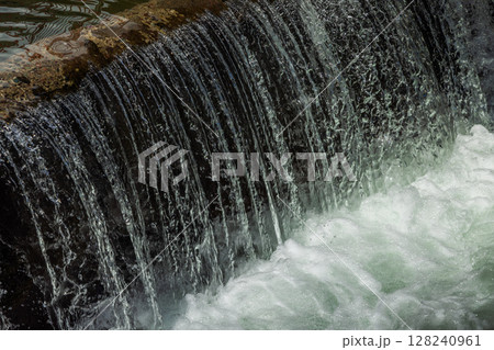 water flowing over concrete structure at sunny day water flowing over concrete structure at sunny day 128240961