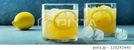 Glasses of lemonade panorama, a mocktail with lemon juice, on a blue background Glasses of lemonade panorama, a mocktail with lemon juice, on a blue background 128241440