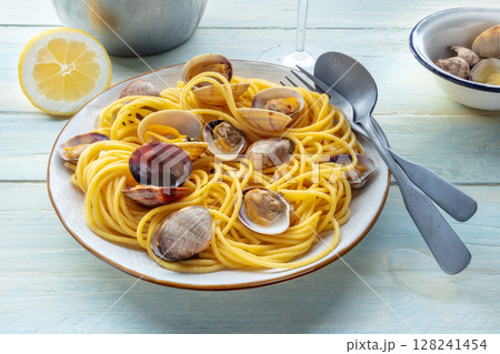 Vongole clams with spaghetti pasta, with lemon, with a wine glass 128241454