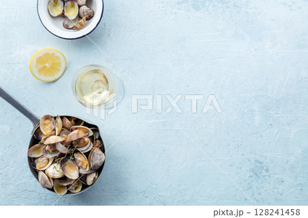 Vongole clams in a sauce pan, overhead flat lay shot with lemon and thyme Vongole clams in a sauce pan, overhead flat lay shot with lemon and thyme 128241458