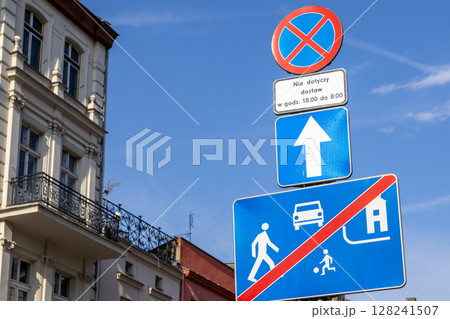 Stacked European road signs clearly regulate urban traffic flow, showing a no parking zone with delivery exception and residential area end Stacked European road signs clearly regulate urban traffic flow, showing a no parking zone with delivery exception and residential area end 128241507