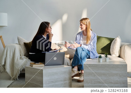 Young smiling girl patient in therapy session with social mental therapist 128243188