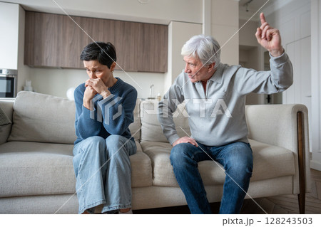 Marital discord in old couple. Shouting aggressive husband arguing with scared wife at home Marital discord in old couple. Shouting aggressive husband arguing with scared wife at home 128243503