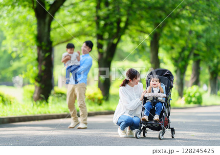 新緑の公園をベビーカーで散歩する親子 128245425