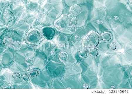 Close-up of abstract turquoise bubbles in liquid. Soft glow, smooth shapes, delicate texture. Macro shot with vibrant light. Fresh, pure, clean concept. Background, chemistry, skincare. Banner Close-up of abstract turquoise bubbles in liquid. Soft glow, smooth shapes, delicate texture. Macro shot with vibrant light. Fresh, pure, clean concept. Background, chemistry, skincare. Banner 128245642