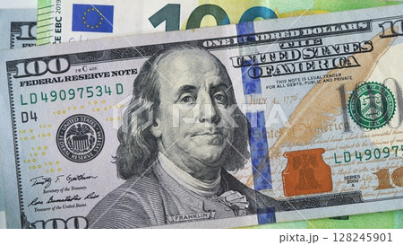 Close-up of US 100 dollar and 100 euro banknotes. Concept of currency exchange, euro-dollar comparison, global market dynamics and financial balance. Close-up of US 100 dollar and 100 euro banknotes. Concept of currency exchange, euro-dollar comparison, global market dynamics and financial balance. 128245901