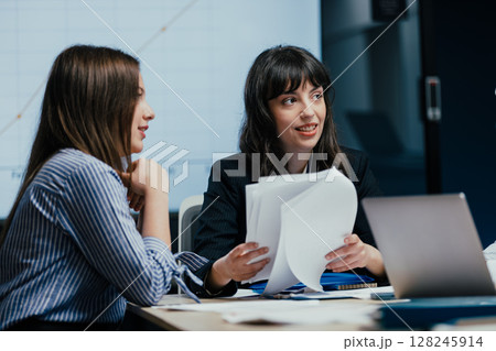 Female colleagues listening attentively to opinion during business meeting in office Female colleagues listening attentively to opinion during business meeting in office 128245914
