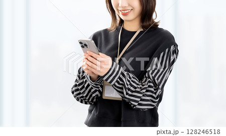 スマートフォンを使う笑顔の女性・ビジネスウーマン 128246518