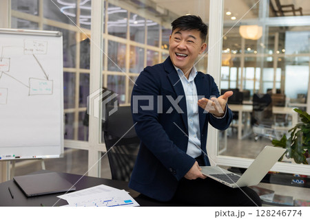 Young asian businessman working on a laptop in his office Young asian businessman working on a laptop in his office 128246774