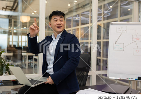 Young asian businessman working on a laptop in his office Young asian businessman working on a laptop in his office 128246775
