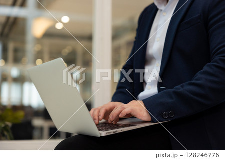 Young asian businessman working on a laptop in his office Young asian businessman working on a laptop in his office 128246776