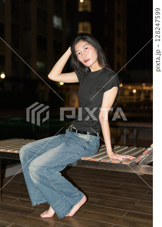 Portrait of beautiful Asian woman at night at pool during holiday Portrait of beautiful Asian woman at night at pool during holiday 128247599