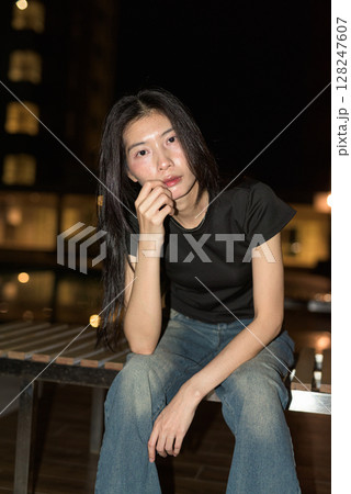 Portrait of beautiful Asian woman at night at pool during holiday 128247607