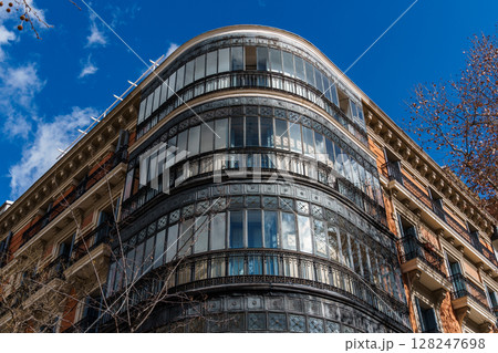 Majestic architecture featuring intricate ironwork and glass in Madrid against a brilliant blue sky. 128247698