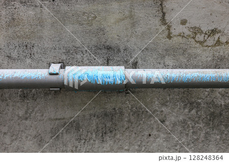 Close up of a wall with water PVC pipe section with Scratches. 128248364