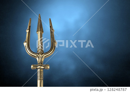 Golden trident over blue misty background 128248787