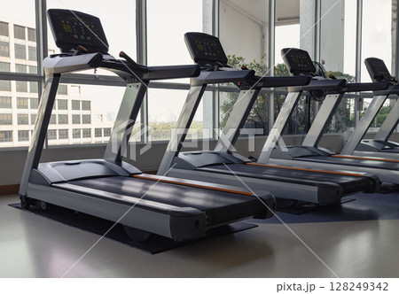 Side view of Two treadmill machines in fitness center. Side view of Two treadmill machines in fitness center. 128249342