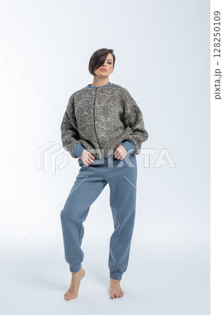 Portrait of young woman warm knitted jumper with zipper on light background. Studio photography. Vertical photo. High quality photo Portrait of young woman warm knitted jumper with zipper on light background. Studio photography. Vertical photo. High quality photo 128250109