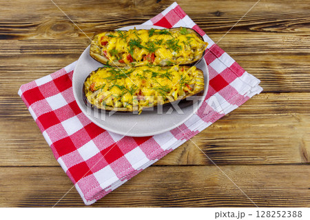 Baked stuffed eggplants on a wooden table. Healthy food and dieting concept 128252388