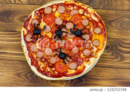 Halloween pizza with spiders on wooden table. Top view Halloween pizza with spiders on wooden table. Top view 128252396