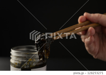 海苔の佃煮を瓶から箸で持ち上げる 海苔の佃煮を瓶から箸で持ち上げる 128253271