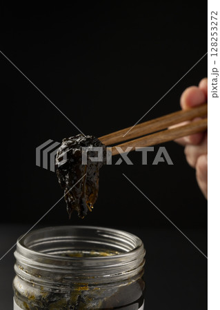 海苔の佃煮を瓶から箸で持ち上げる 海苔の佃煮を瓶から箸で持ち上げる 128253272