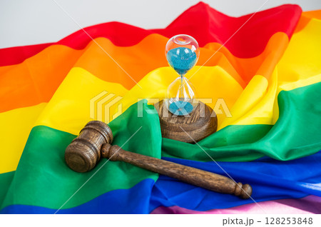 Judge's gavel and hourglass on rainbow flag.  128253848