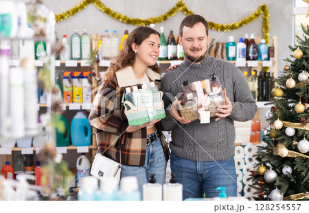Positive family couple choosing gifts for New Year in household department of supermarket 128254557