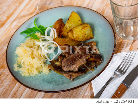 Rabbit liver dish with boiled potatoes and sauerkraut closeup 128254931