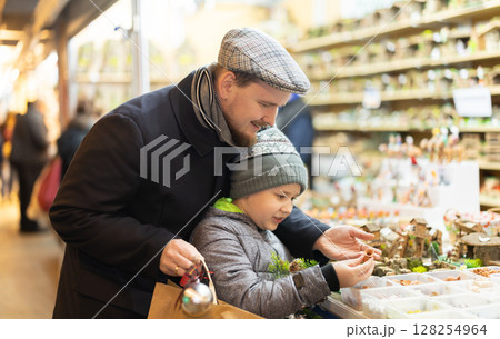 Father and son choose figures for the nativity scene 128254964
