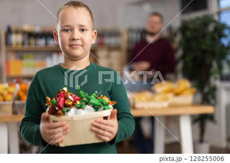 Boy choosing candies in grocery store 128255006