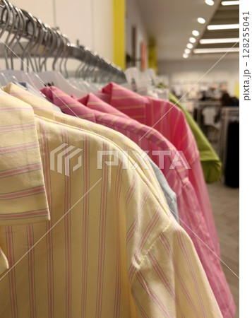 colorful shirts hanging on racks in modern retail store spring summer fashion trends. closeup. colorful shirts hanging on racks in modern retail store spring summer fashion trends. closeup. 128255041