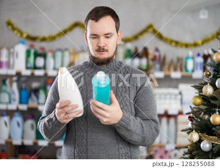 On New Year Eve, man choose and buy shampoo bottle On New Year Eve, man choose and buy shampoo bottle 128255088