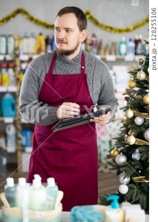 Cleaning supplies store owner reviewing stock levels on tablet Cleaning supplies store owner reviewing stock levels on tablet 128255106