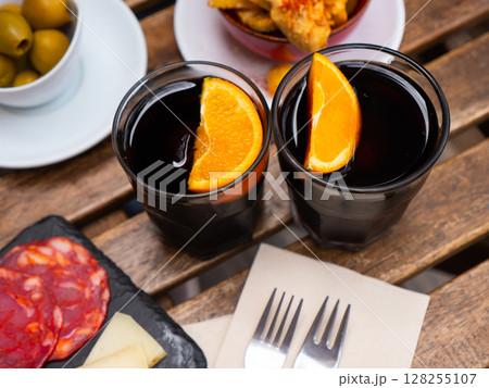 Red vermouth garnished with orange served with Spanish tapas Red vermouth garnished with orange served with Spanish tapas 128255107
