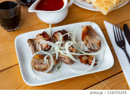 Grilled pork meat shashlik with sliced onion 128255293