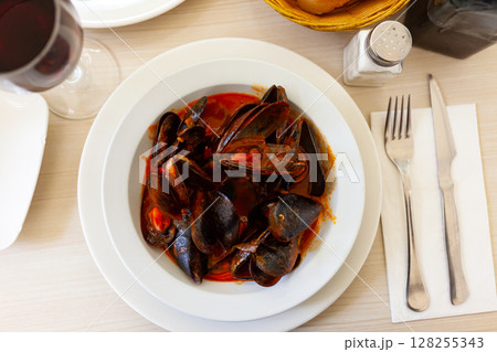 Delicious boiled mussels with tomato sauce and parsley Delicious boiled mussels with tomato sauce and parsley 128255343