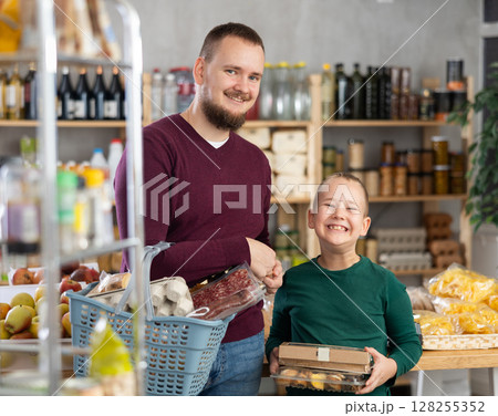 Man and his son choose groceries in a supermarket 128255352