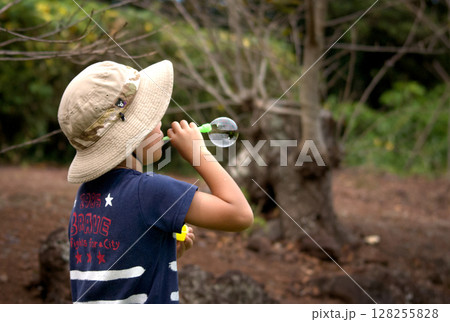 <素材>公園でシャボン玉を吹いて遊ぶ少年 <素材>公園でシャボン玉を吹いて遊ぶ少年 128255828