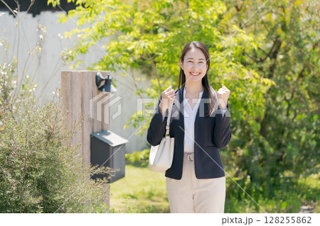 家の表札の前に立つ女性 128255862