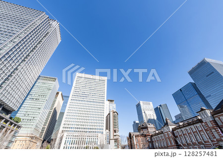 東京都千代田区丸の内　快晴のJR東京駅（重要文化財の丸の内駅舎）と周辺の高層ビル群 128257481