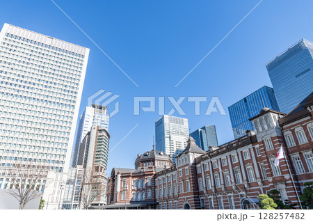 東京都千代田区丸の内　快晴のJR東京駅（重要文化財の丸の内駅舎）と周辺の高層ビル群 128257482