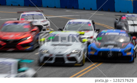 Motion blur race car racing on speed track, Motion blurred super car race on street track circuit, Automobile automotive transportation vehicle background, 128257629