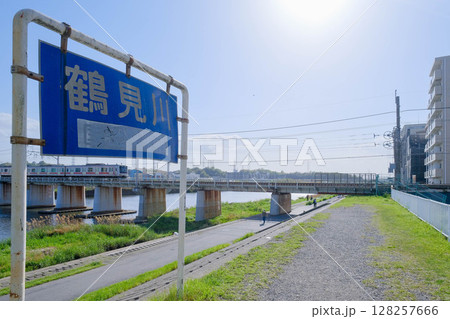 鶴見川の看板と東横線の電車 128257666