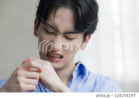 蚊に刺された若い男性 128258197
