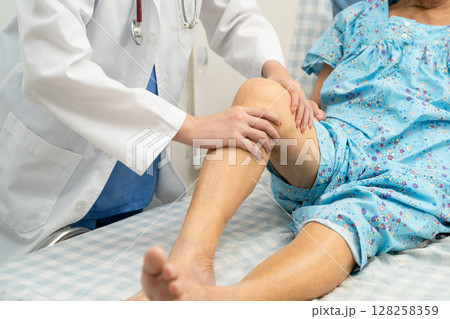 Doctor checking Asian elderly woman patient knee replacement surgery in hospital. Doctor checking Asian elderly woman patient knee replacement surgery in hospital. 128258359
