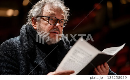 Man reading documents close up portrait dark clothing serious expression 128258929