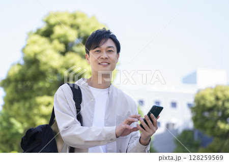 スマートフォンを持ったカメラ目線の40代の男性 スマートフォンを持ったカメラ目線の40代の男性 128259569