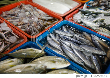 Asian fish market, fresh seafood assortment with various types of fish on trays 128259655